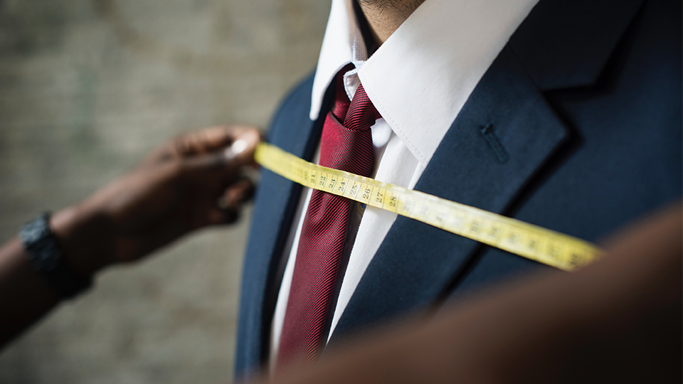 Man being measured by shoulders, illustrating customization and accuracy options in Intraday Pricing Service setup.